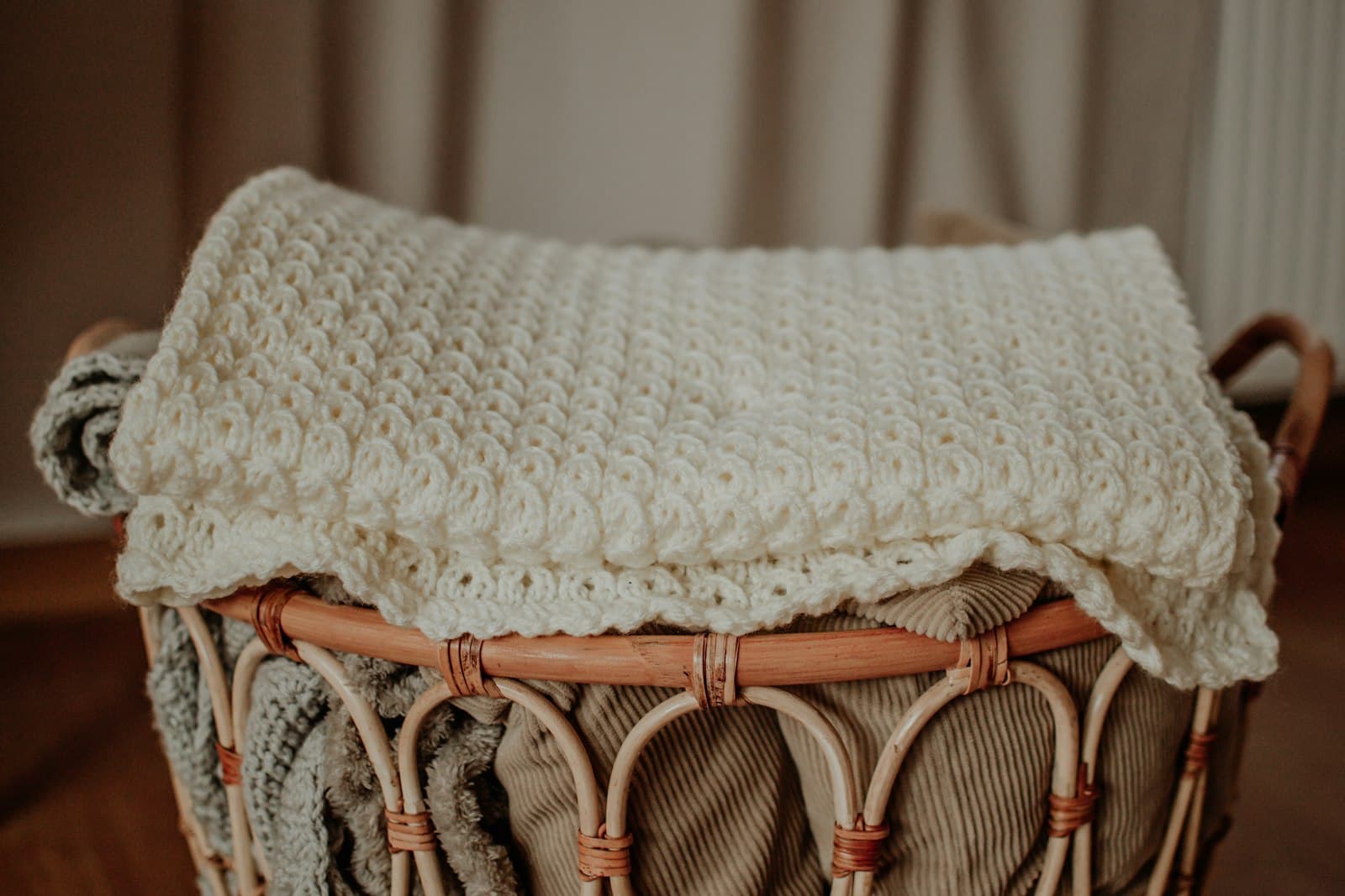 A woven basket of folded baby blankets